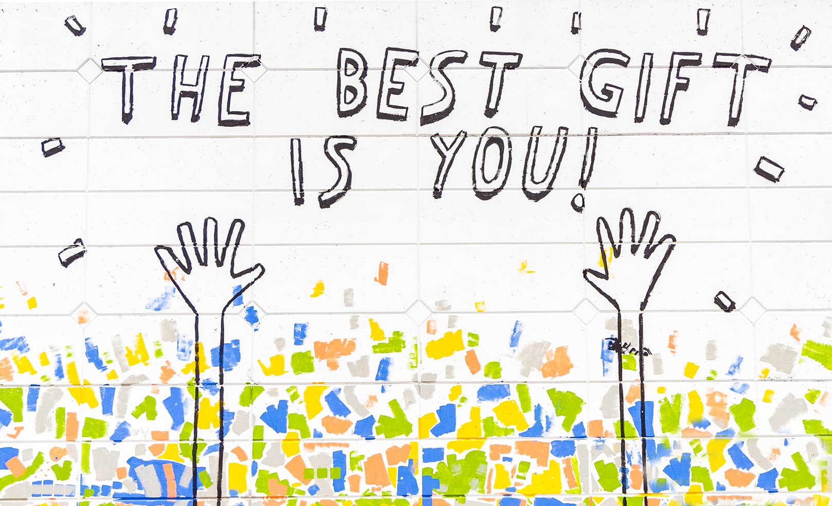 Words on a white brick wall "The Best Gift is You!"